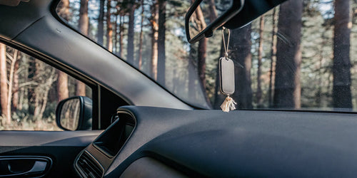 Air freshener hanging from the rearview mirror inside a car.